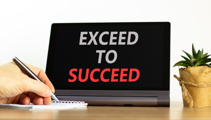 Exceed to succeed symbol. Concept words Exceed to succeed on beautiful tablet screen. Beautiful wooden table white background. Businessman hand. Business and exceed to succeed concept. Copy space.