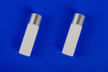 Plastic white tube for cream or lotion. Skin care or sunscreen cosmetic on blue background 