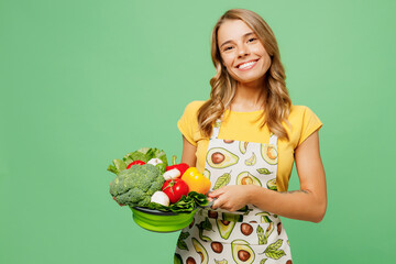 Young smiling housewife housekeeper chef cook baker woman wear apron yellow t-shirt hold in hand...