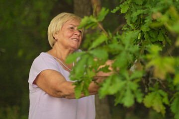 Fototapeta premium With a soft grasp, the elder connects with the tree, embodying the principle that every age can contribute to nature's care.