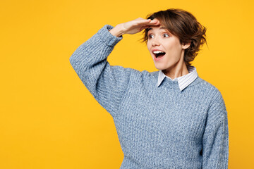 Young surprised shocked woman she wears grey knitted sweater shirt casual clothes hold hand at...