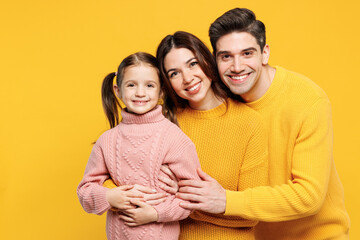 Close up young fun happy parents mom dad with child girl 7-8 years old wearing pink knitted sweater...