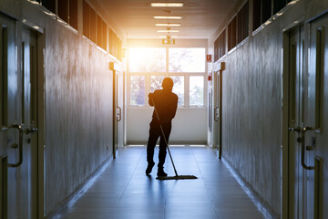 Janitor man mopping floor in hallway office building or walkway after school and classroom...