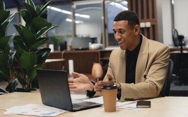 Young man using laptop and smiling at office.