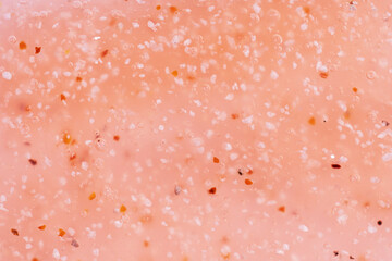 Cosmetics scrub texture swatch, body peeling in peach fuzz color. Top view.