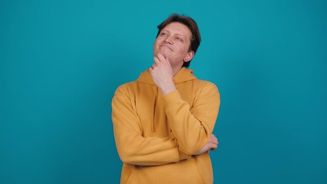 Young man thinks deeply about something tries to make decision in mind. Pondering a solution, doubting question. Let me think. Emotions. People. Lifestyle concept.