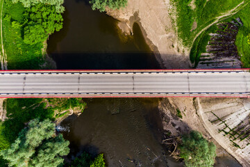 Top view of an asphalt road bridge and a small river