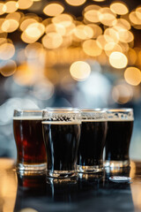 Glass pint of cold draft light lager or dark ale brewed beer with foam on table background. Brewery or pub bar advertising. Oktoberfest festival alcohol beverage or Saint Patricks day drink concept .