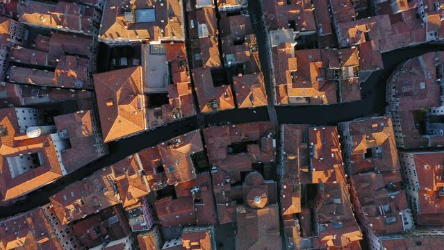Top down view of canals with gondola and house roofs in the old town, Venice, Italy