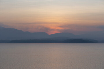 Beautiful morning scenery of River and mountain in a dramatic sky, the magic of sunset and sunrise, with a symphony of colors - orange, red, blue, and yellow, a colorful horizon of nature