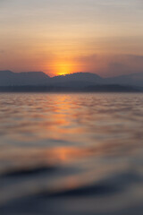 Beautiful morning scenery of River and mountain in a dramatic sky, the magic of sunset and sunrise, with a symphony of colors - orange, red, blue, and yellow, a colorful horizon of nature