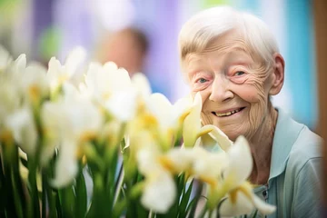 Möbelaufkleber elderly lady beaming with a bunch of irises at a floral exhibition © primopiano