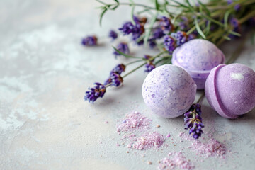 Obraz premium Purple bath bombs with dried lavender buds by fresh sprigs on a light concrete background with copy space, for natural handmade cosmetic stores and wellness concept