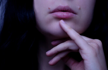Portrait of a beautiful brunette woman. Natural beauty. Hand and lips close-up.