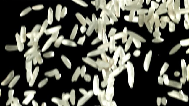 Grains of rice falling on black background. Filmed on a high-speed camera at 1000 fps. High quality FullHD footage