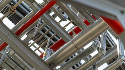 Close-up of metal structure with red pipes, petrochemical plant, processing of petroleum products.