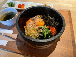 テーブルの上のトレイに盛り付けられた石焼ビビンパ（韓国料理）
