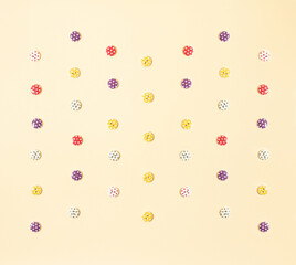 Dreamy beige pattern background with red, pink, blue, green, orange and yellow buttons with stars. Spring pattern.. Artistic toned image. Pastel toned. Minimal flat lay concept.