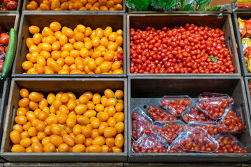 Tomatoes in wooden boxes in the fruit and vegetable section of a grocery supermarket. Sale of tomatoes. Vegetables in a grocery store.