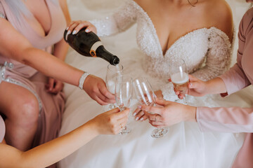 Photo bride with her friends drinking champagne from glasses. Cropped shot of a beautiful young...