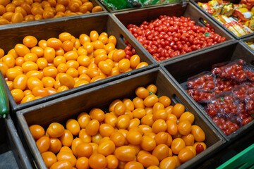 Tomatoes in wooden boxes in the fruit and vegetable section of a grocery supermarket. Sale of tomatoes. Vegetables in a grocery store.