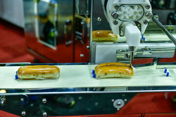 Automatic hamburger buns production line on conveyor belt equipment machinery in factory, industrial food production.