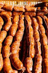 Fresh raw homemade chorizo sausages placed in container in sunlight