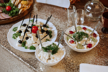 Meat and cheese snacks on the buffet. A buffet in a closed room, at a wedding celebration or birthday. Sandwiches on skewers before the start of the holiday.