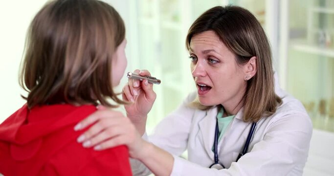 Doctor ENT examination of throat of child in clinic. Inflammation of tonsils in children and viral tonsillitis