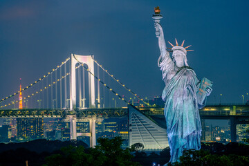 Odaiba Nightlights: Statue of Liberty and Rainbow Bridge Illuminated in Tokyo Bay - obrazy, fototapety, plakaty