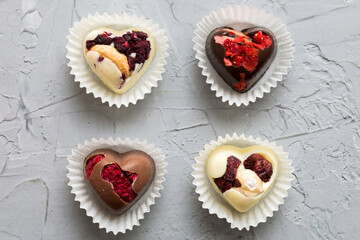 chocolate sweets in the form of a heart with fruits and nuts on a colored background. top view with space for text, holiday concept