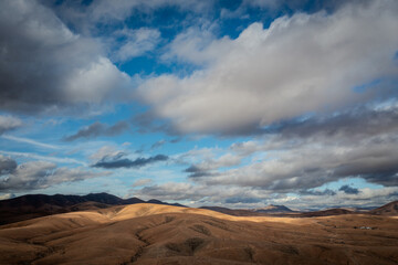 aerial view of a desert landscape on fuerteventura with a cloudy blue sky