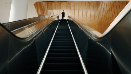 Professional business man using phone calling while using escalator. Skilled caucasian executive...