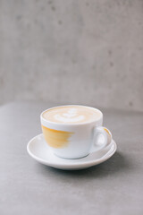 Close-up of a cup of latte or cocoa on a gray stone background.
