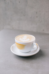 Close-up of a cup of latte or cocoa on a gray stone background.