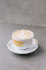Close-up of a cup of latte or cocoa on a gray stone background.