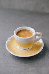 Close up of a cup of espresso or dopio on a gray stone background.