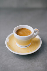 Close up of a cup of espresso or dopio on a gray stone background.
