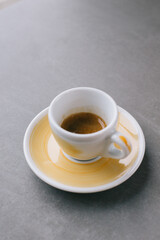 Close up of a cup of espresso or dopio on a gray stone background.