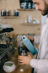 A barista pours milk from a cardboard box. The process of making coffee or matcha.
