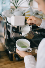 Barista prepares tasty and healthy matcha latte tea..