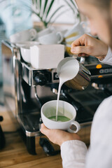 Barista prepares tasty and healthy matcha latte tea..