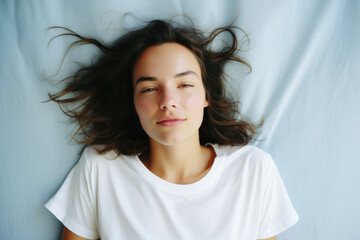 Fototapeta premium Young adult pretty woman beauty model wearing white t-shirt posing with eyes closed on color background. Face flawless fresh skin hair care cosmetic treatment makeup products skincare ads .