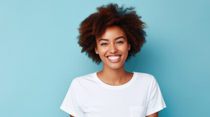 Young happy smiling African American woman model wearing tshirt standing on color background. Face skin hair care cosmetics makeup, fashion ads. Beauty portrait. White t-shirt mock up template . - obrazy, fototapety, plakaty