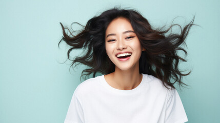 Fototapeta premium Young happy smiling Asian woman model wearing tshirt looking at camera on color background. Face skin hair care korean cosmetic and makeup, fashion ads. Beauty portrait. White t-shirt mock up template