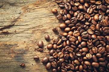 a pile of coffee beans on a wood surface