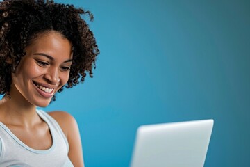 a woman smiling at a laptop