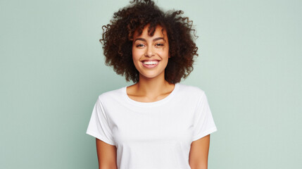Young happy smiling African American woman model wearing tshirt standing on color background. Face...