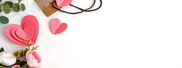Background for Valentine's Day. Pink hearts and flowers on a light background. Flat layout and a place to copy