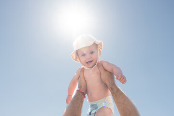 Father and child in a playful sky-high embrace under the sun. Concept of happiness and fatherly affection